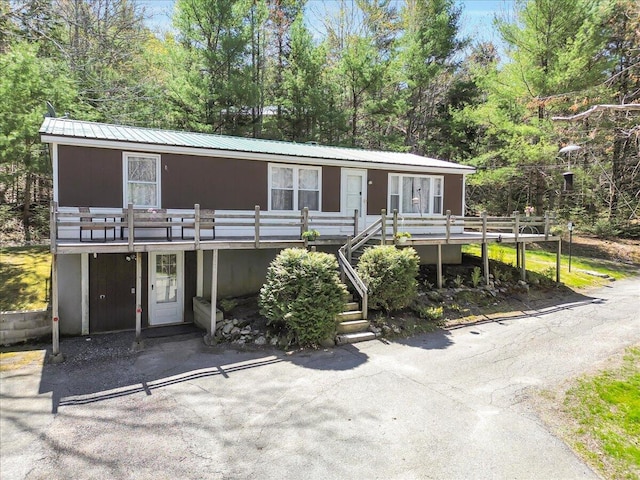 1270 Main St, Mount Desert, ME 04660 - view of front of property with a deck, metal roof, stairway, and view of wooded area