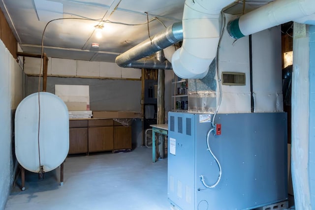 unfinished below grade area featuring oil tank and heating unit