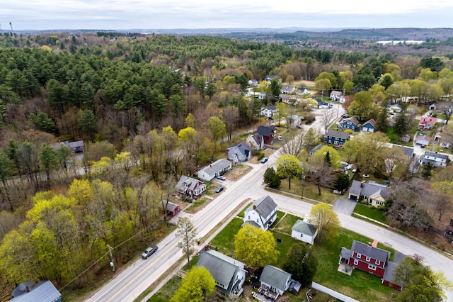 view of property location featuring a forest and nearby suburban area