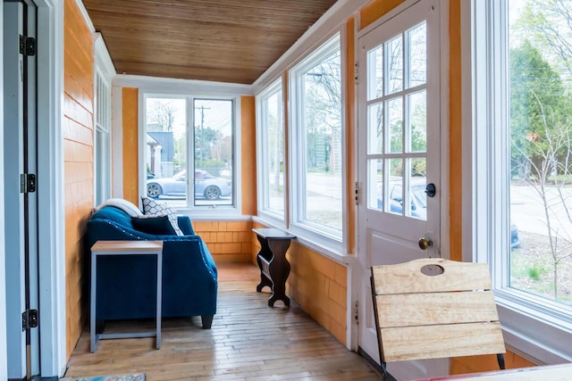 sunroom / solarium featuring healthy amount of natural light, wooden ceiling, and hardwood / wood-style floors