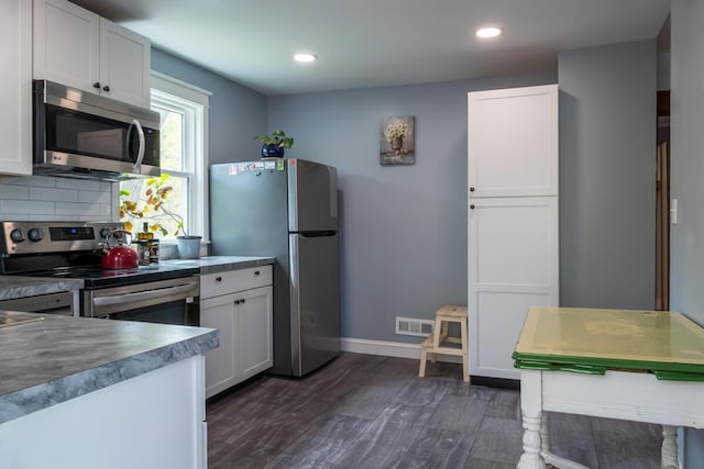 kitchen with stainless steel appliances, white cabinets, dark wood-style flooring, and recessed lighting