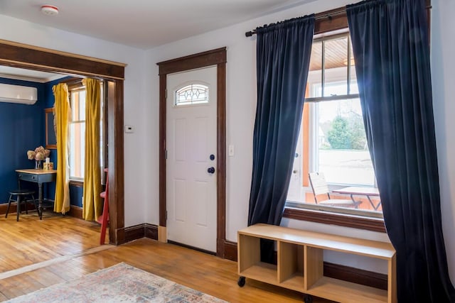 entryway featuring a wall mounted AC, wood finished floors, and baseboards