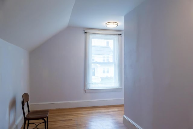 bonus room with vaulted ceiling, wood finished floors, and baseboards