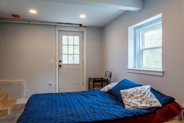 bedroom with multiple windows, wood finished floors, recessed lighting, and baseboards