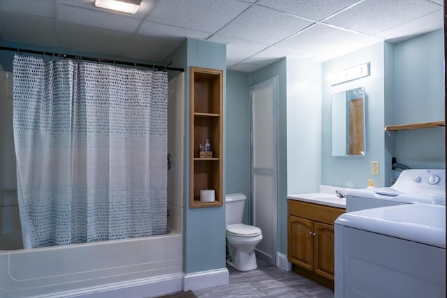 bathroom with a drop ceiling, vanity, toilet, shower / bath combo, and washer and clothes dryer