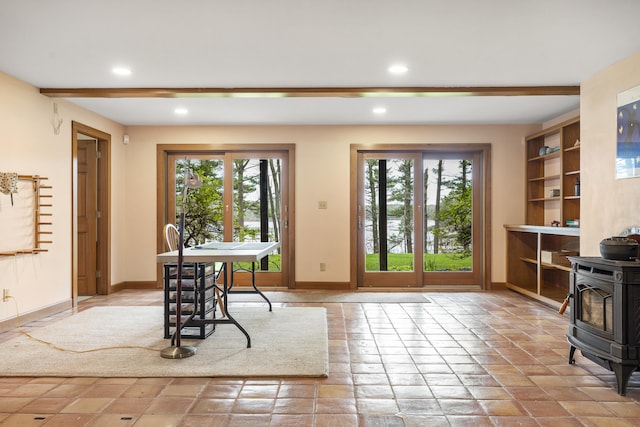 doorway featuring a wood stove, baseboards, and recessed lighting