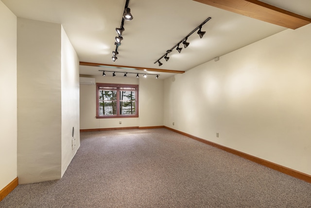 spare room featuring track lighting, carpet, a wall mounted air conditioner, and baseboards