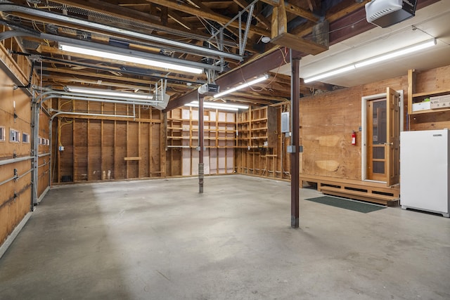 garage featuring freestanding refrigerator and a garage door opener