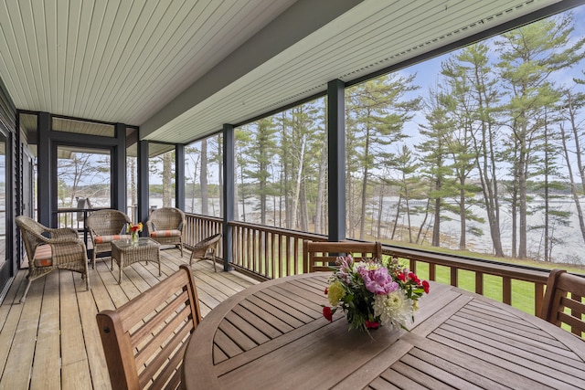 sunroom / solarium with a water view, outdoor dining area, healthy amount of natural light, and an outdoor hangout area