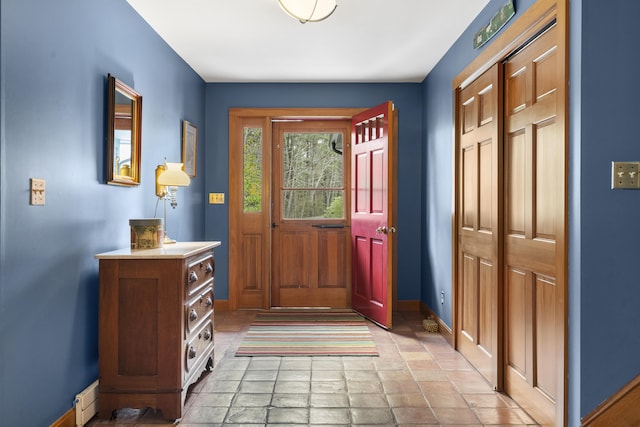 entrance foyer with light stone finish floors and baseboards