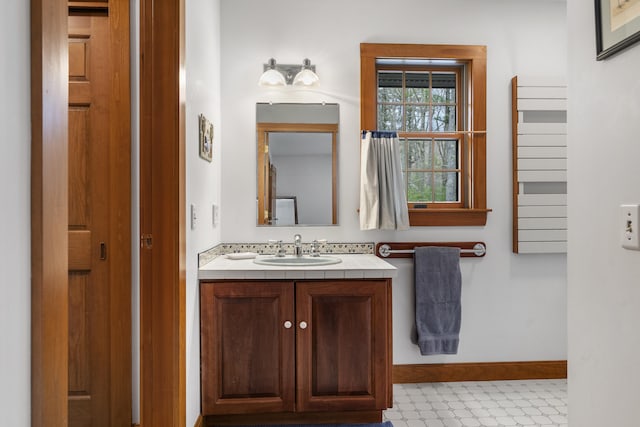 bathroom with tile patterned floors, baseboards, and vanity