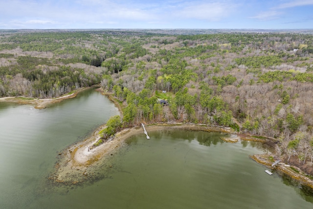 aerial view of property's location featuring a forest and a nearby body of water