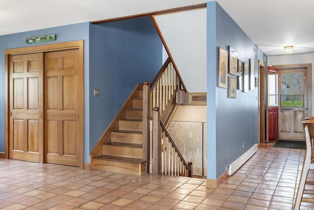 staircase with baseboards and a baseboard heating unit