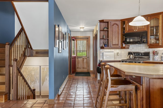 kitchen with black microwave, stove, open shelves, tasteful backsplash, and brown cabinets
