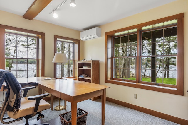 office featuring an AC wall unit, a water view, baseboards, rail lighting, and carpet