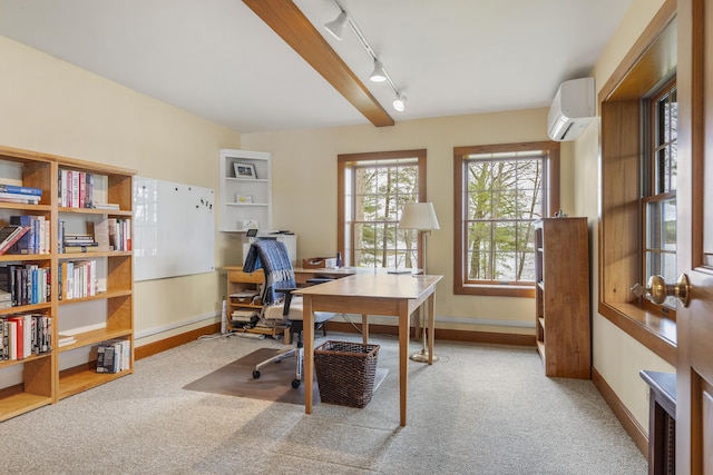 office space with an AC wall unit, carpet floors, baseboards, and track lighting