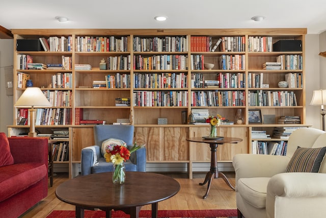 living area featuring bookshelves and wood finished floors