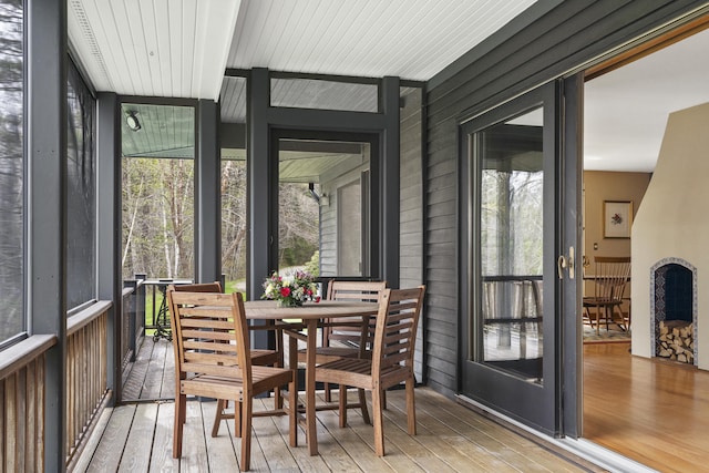 sunroom / solarium featuring plenty of natural light and outdoor dining area