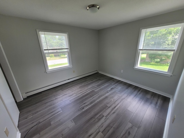 110 Lincoln St, Old Town, ME 04468 - empty room featuring a baseboard heating unit, plenty of natural light, dark wood finished floors, and baseboards