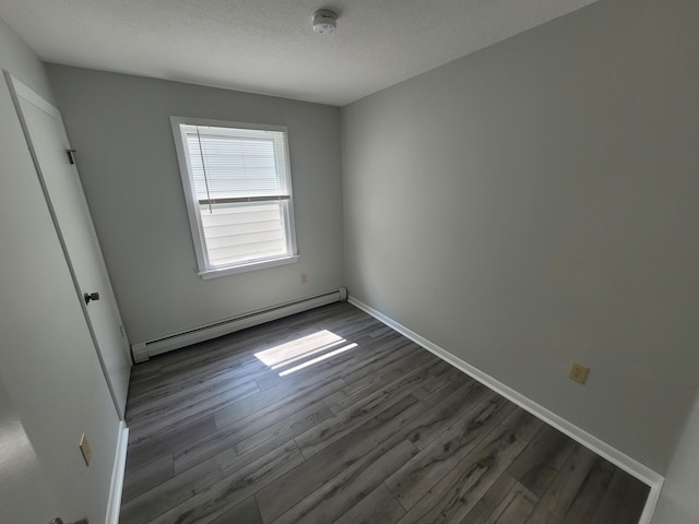 110 Lincoln St, Old Town, ME 04468 - unfurnished bedroom featuring a baseboard radiator, dark wood-style flooring, a textured ceiling, and baseboards