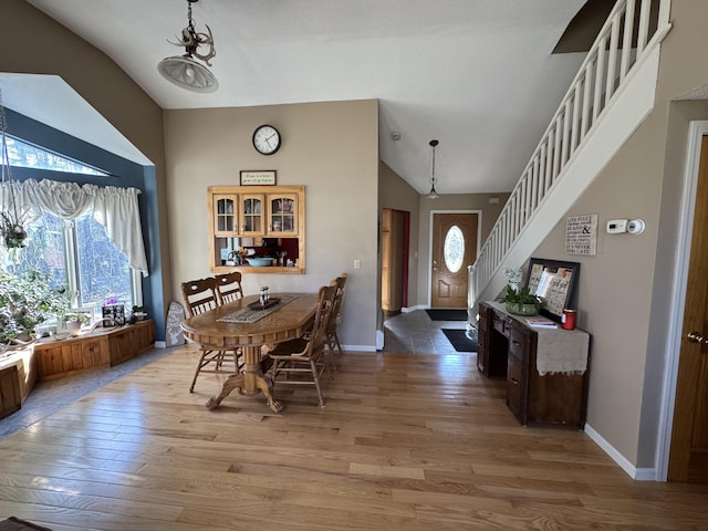43 Webb River Dr, Dixfield, ME 04224 - dining room with light wood-style flooring, baseboards, stairway, and high vaulted ceiling
