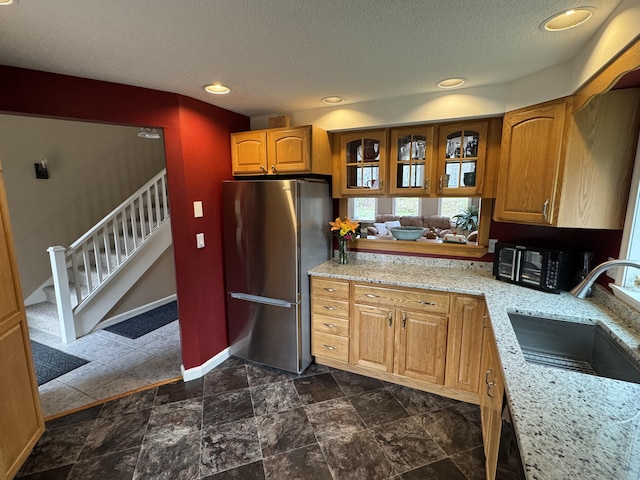 43 Webb River Dr, Dixfield, ME 04224 - kitchen with freestanding refrigerator, a sink, a textured ceiling, light stone countertops, and baseboards