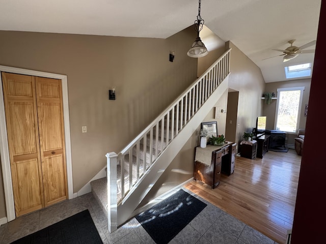 43 Webb River Dr, Dixfield, ME 04224 - staircase featuring lofted ceiling, a ceiling fan, tile patterned floors, a skylight, and baseboards