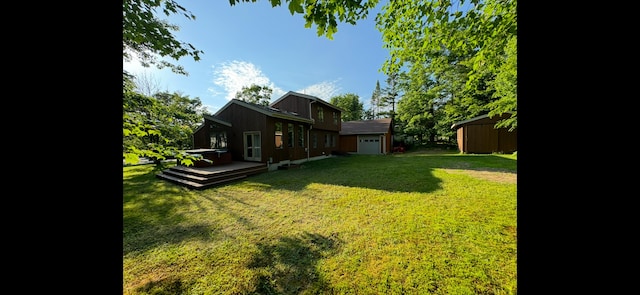 43 Webb River Dr, Dixfield, ME 04224 - view of green lawn featuring a wooden deck, a garage, a storage unit, and an outdoor structure