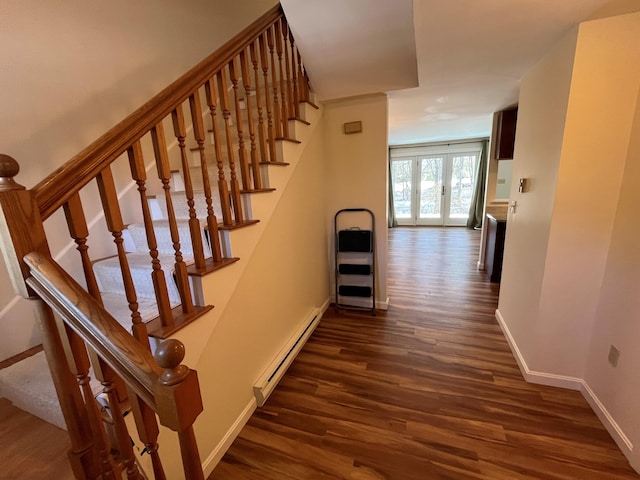 stairway with a baseboard radiator, wood finished floors, and baseboards
