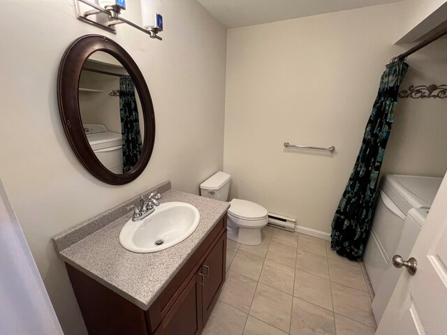 full bathroom featuring toilet, washer and clothes dryer, baseboard heating, vanity, and tile patterned flooring