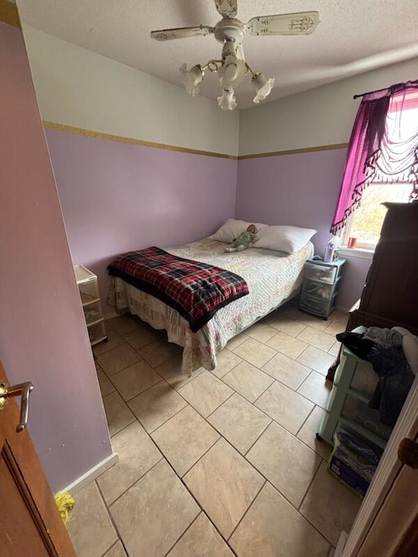 623 Gore Rd, Otisfield, ME 04270 - bedroom with light tile patterned floors, a ceiling fan, and a textured ceiling