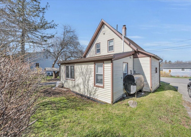 view of side of property featuring heating fuel and a yard