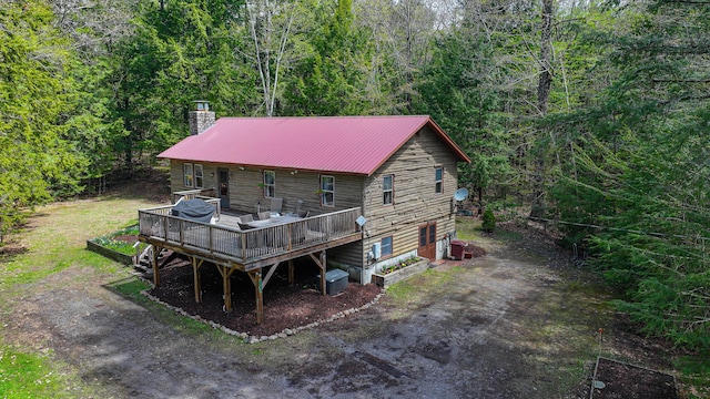 124 Alpine Village Rd, Harrison, ME 04040 - rear view of property featuring a deck, a chimney, metal roof, a forest view, and central AC unit