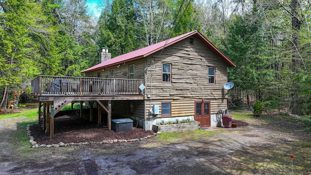 124 Alpine Village Rd, Harrison, ME 04040 - back of property featuring a wooden deck, stairs, a chimney, and a view of trees