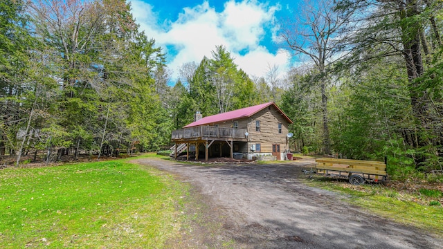 124 Alpine Village Rd, Harrison, ME 04040 - view of front of property with a wooden deck, a front yard, a view of trees, dirt driveway, and stairway