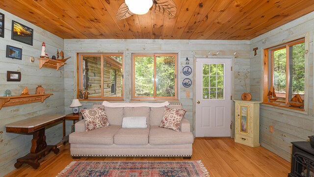 124 Alpine Village Rd, Harrison, ME 04040 - living room with wooden ceiling, light wood-style floors, wood walls, a ceiling fan, and a wood stove