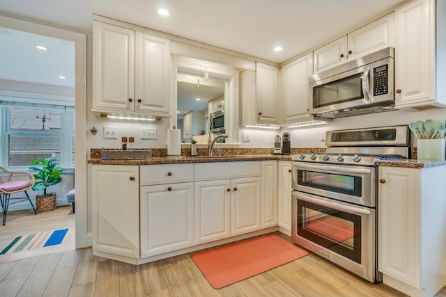 4 Union Ave, Old Orchard Beach, ME 04064 - kitchen with appliances with stainless steel finishes, dark stone counters, a sink, light wood finished floors, and recessed lighting