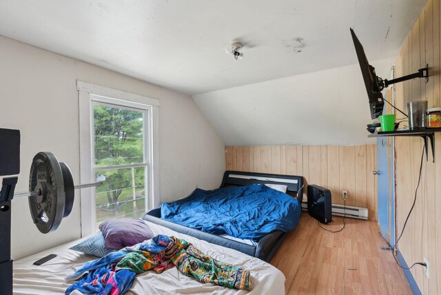 14 N St, Augusta, ME 04330 - bedroom with baseboard heating, wood walls, light wood-style floors, and lofted ceiling