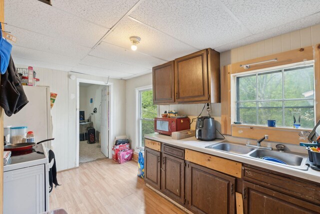 14 N St, Augusta, ME 04330 - kitchen with a sink, light wood-type flooring, light countertops, a paneled ceiling, and brown cabinets
