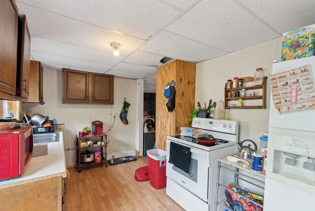 14 N St, Augusta, ME 04330 - kitchen with white appliances, light wood-style flooring, light countertops, a paneled ceiling, and brown cabinets
