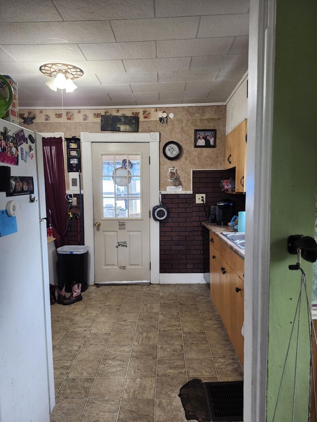 kitchen with freestanding refrigerator and light countertops