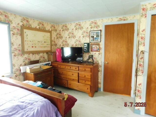 bedroom featuring wallpapered walls and carpet flooring