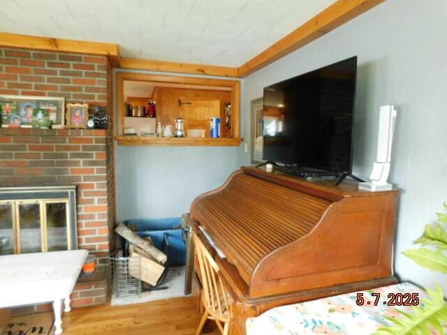 living room featuring wood finished floors and a brick fireplace