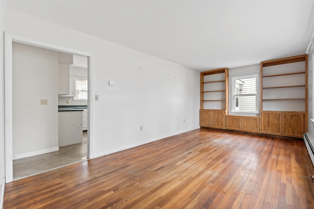 unfurnished living room with hardwood / wood-style floors, healthy amount of natural light, and baseboards
