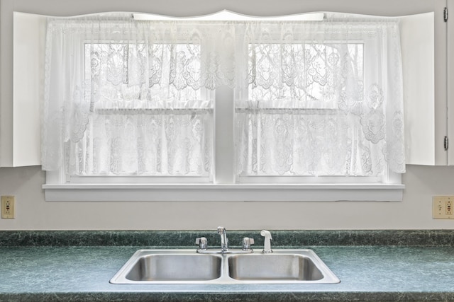 kitchen view of a sink and dark countertops