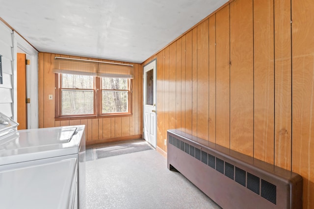 laundry room with radiator heating unit, wood walls, and baseboards