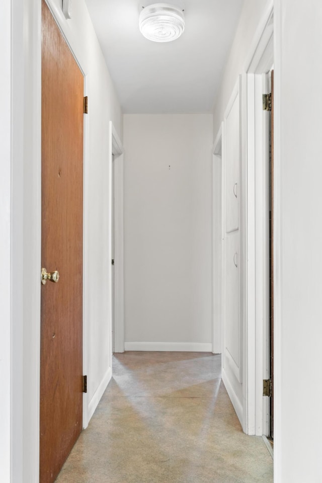 corridor with light colored carpet and baseboards