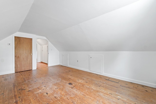 bonus room featuring hardwood / wood-style floors, vaulted ceiling, and baseboards