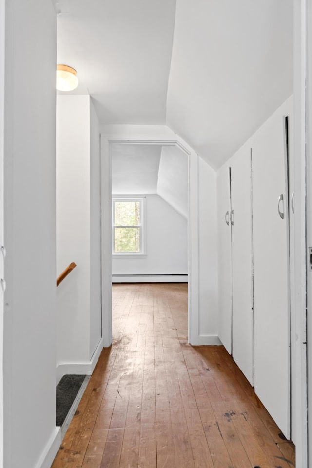 bonus room with a baseboard radiator, hardwood / wood-style floors, and vaulted ceiling