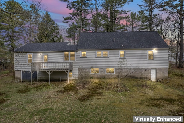 back of house at dusk with a deck and roof with shingles